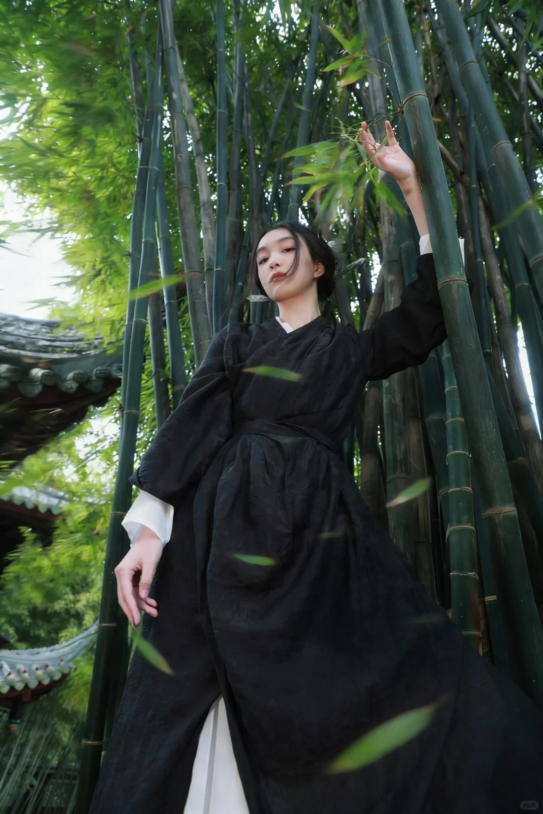 Wuxia meaning expressed in a contemporary bamboo-grove portrait of a woman in dark martial costume