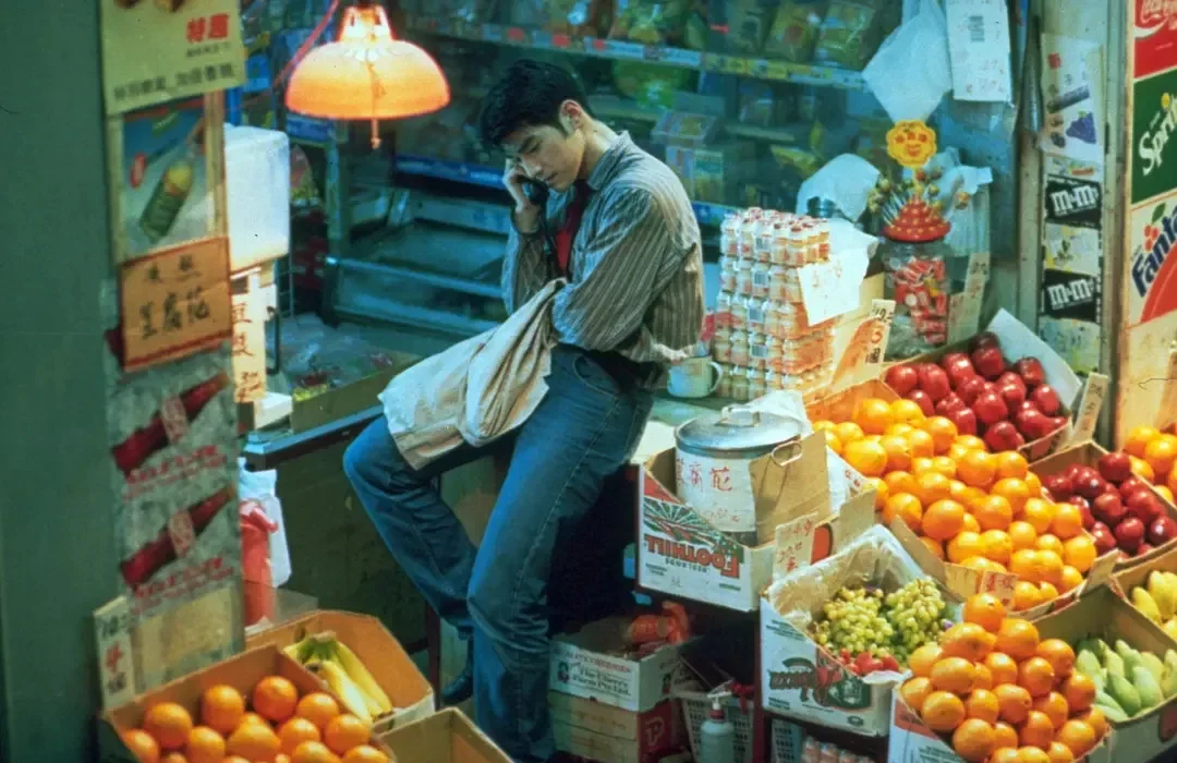 Cop 223 sits on a phone call inside a crowded Hong Kong fruit stand in Chungking Express