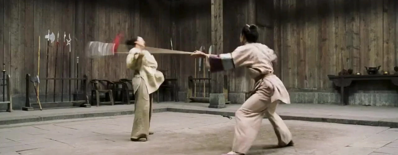 Yu Shu Lien drives a long weapon toward Jen Yu during the weapons-room fight