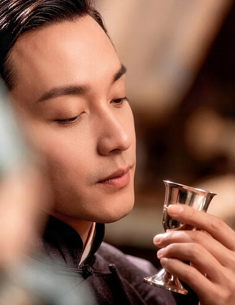 Leslie Cheung as Dieyi offstage holding a metal cup, without the complete opera face