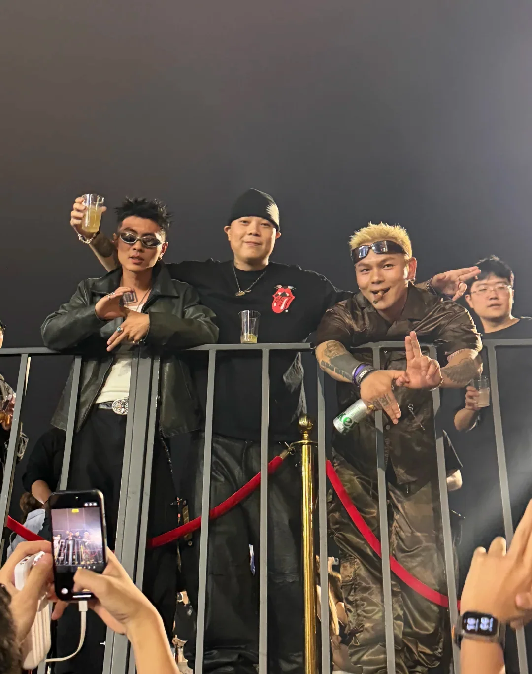 Sheng Yu, KEY.L Liu Cong and KungFu-Pen standing together behind a crowd barrier at a live event