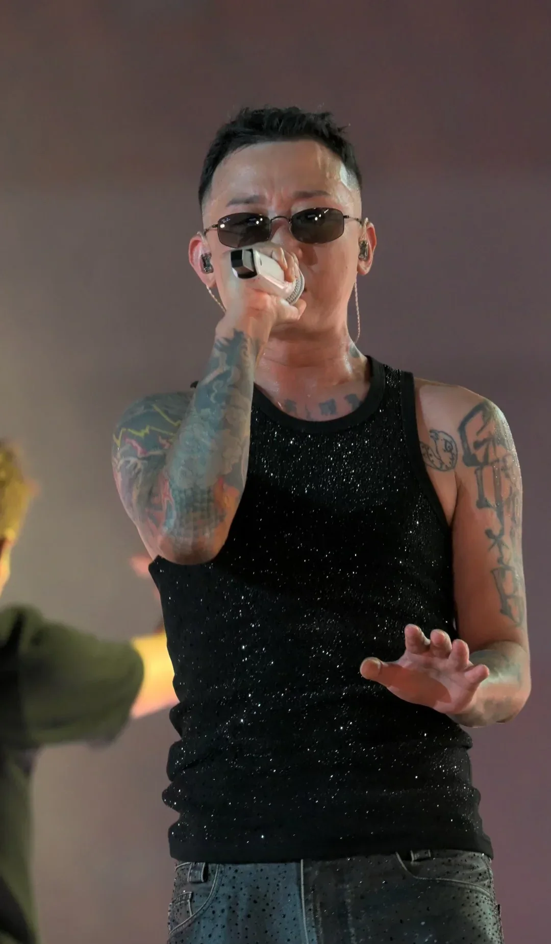 A close front-row view of GAI Zhou Yan performing Chaotianmen in a black vest and sunglasses