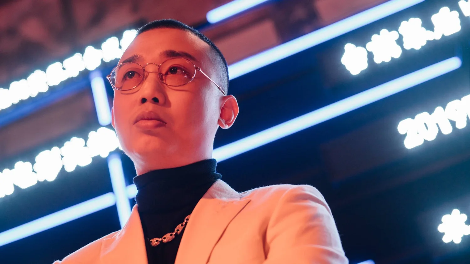 GAI Zhou Yan in an official portrait under red and blue stage lighting