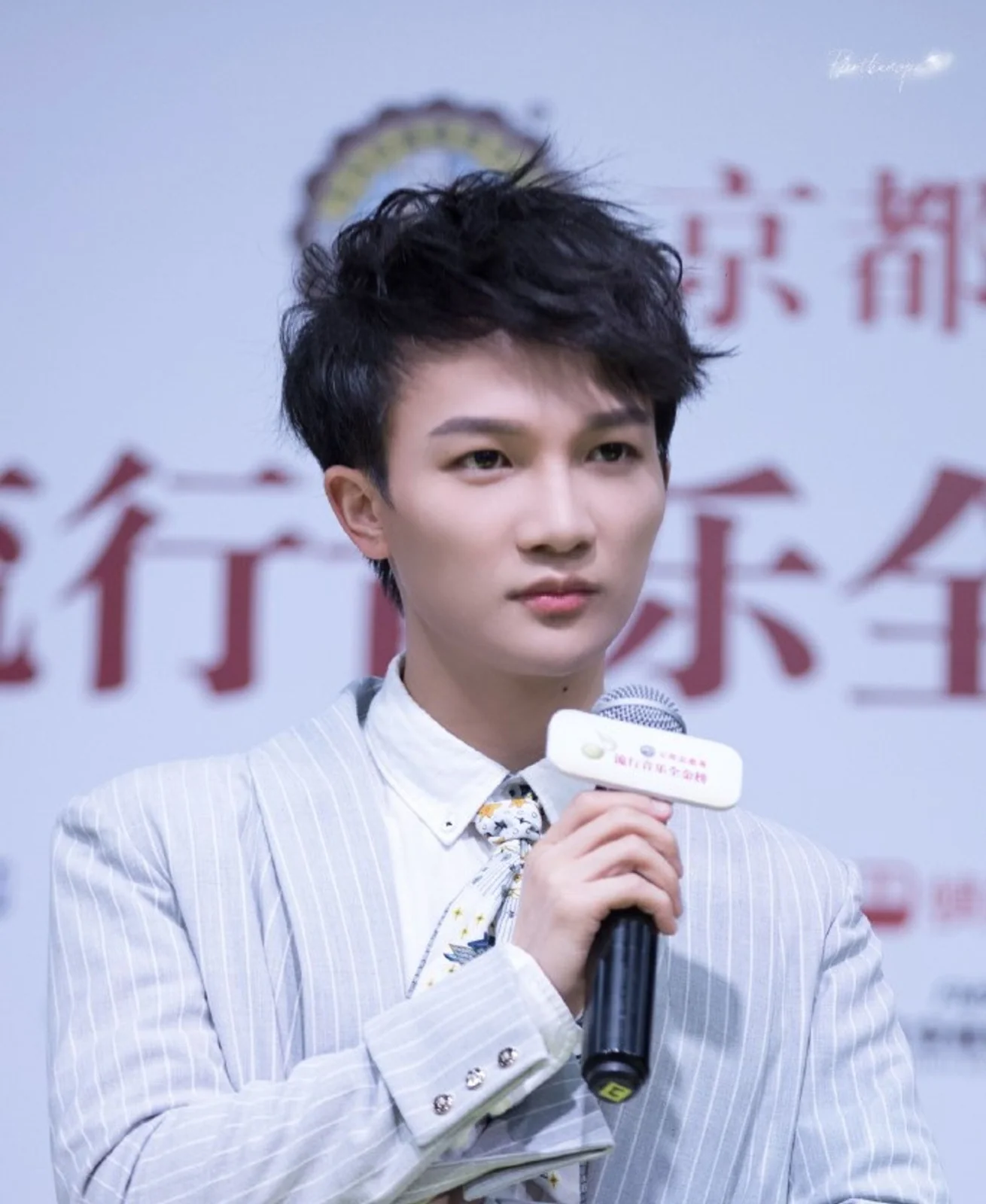 Zhou Shen singing into a handheld microphone at the 2019 Golden Chart awards