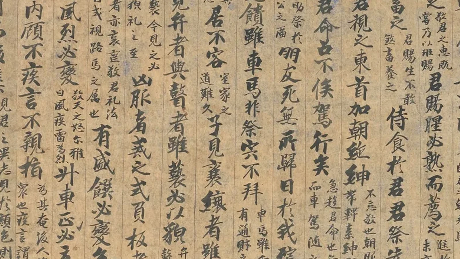 Close view of a Dunhuang Analects manuscript where large base text and smaller commentary occupy the same written surface