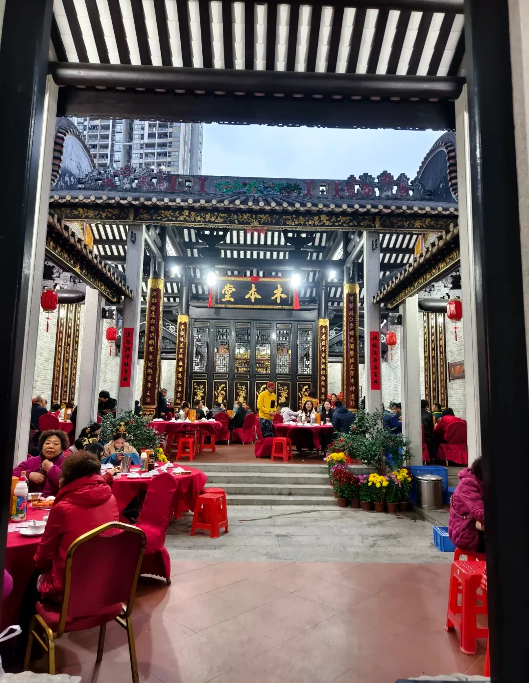 Several generations sharing a New Year meal inside a Liedecun ancestral hall in Guangzhou