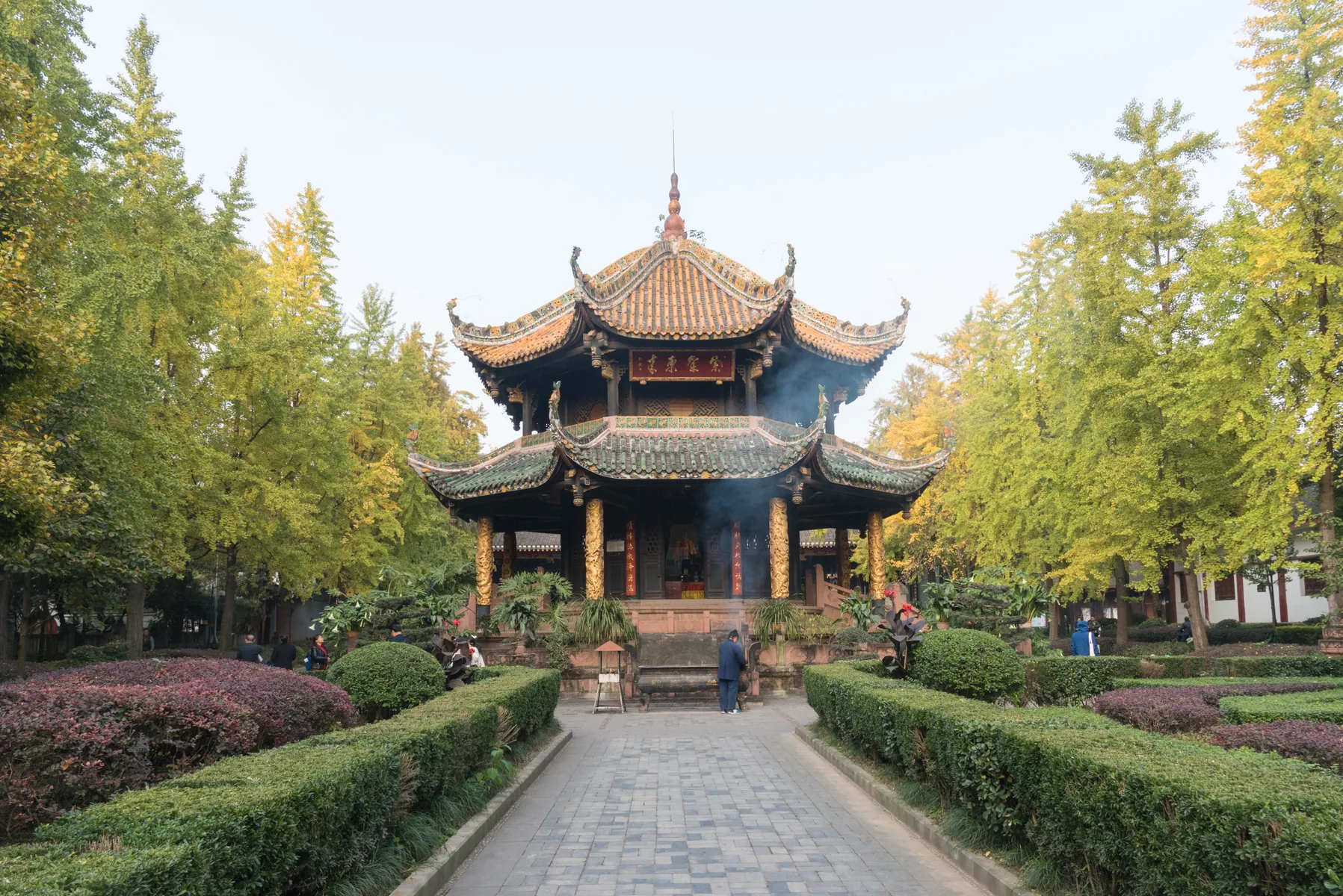 Incense rises before a hall at Qingyang Palace in Chengdu while visitors move through the grounds
