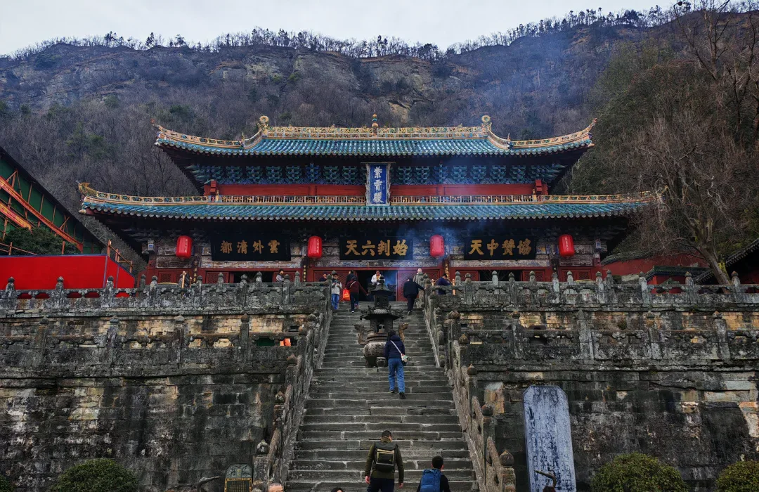 Visitors climbing the central stairs toward Purple Heaven Hall at Wudang through incense smoke