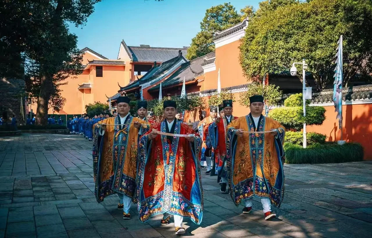Daoist ritual participants moving in an ordered procession through the Longhu Mountain temple grounds