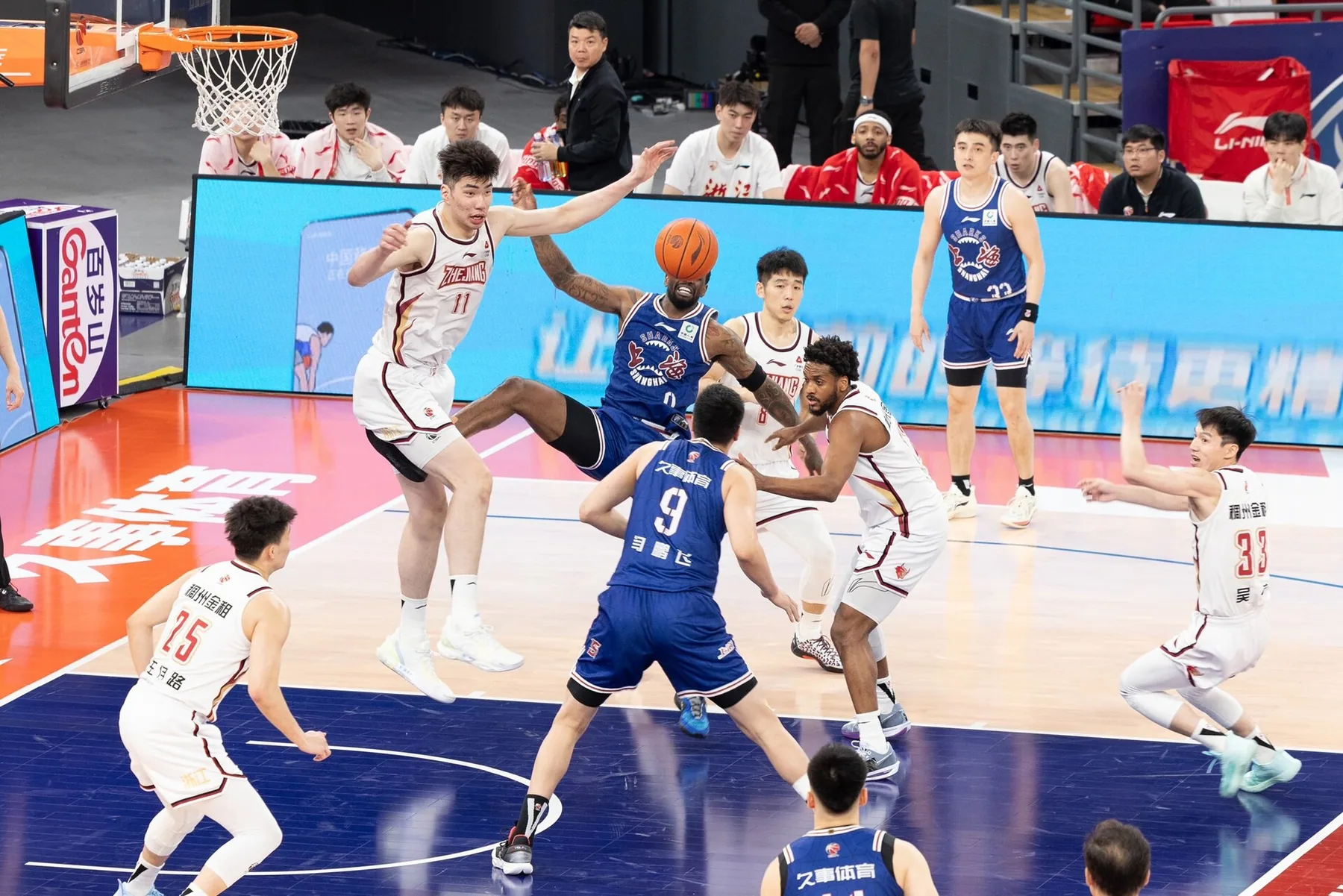 Shanghai Sharks and Zhejiang Golden Bulls players contest a rebound during a 2024 CBA playoff game