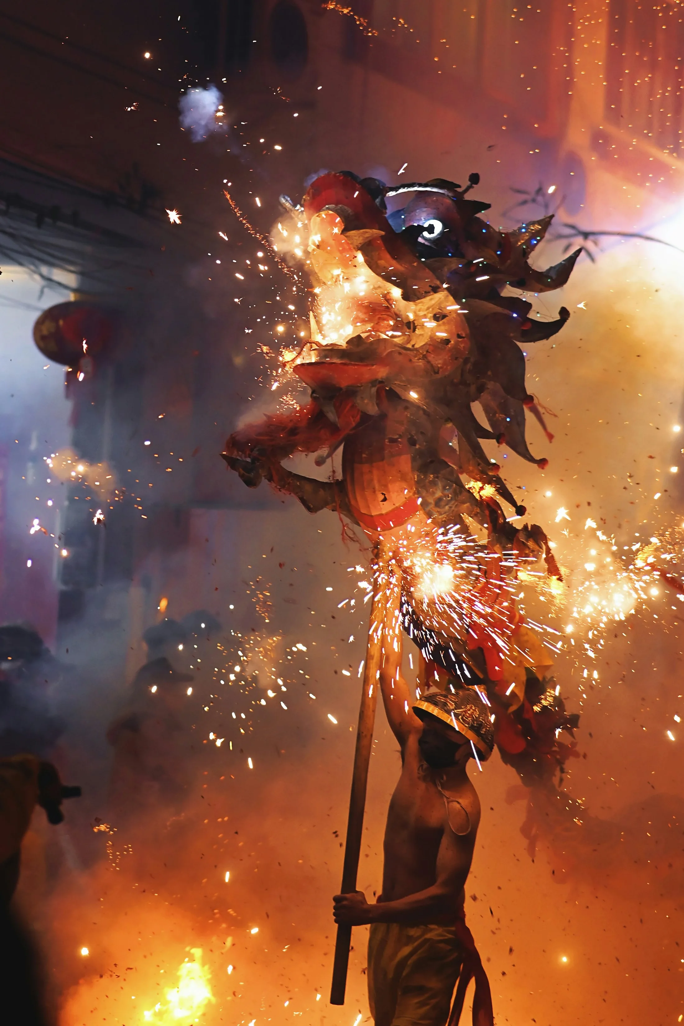 Chinese dragon vs Western dragon: a performer raises a fire-dragon head amid sparks at the Binyang Fire Dragon Festival in China
