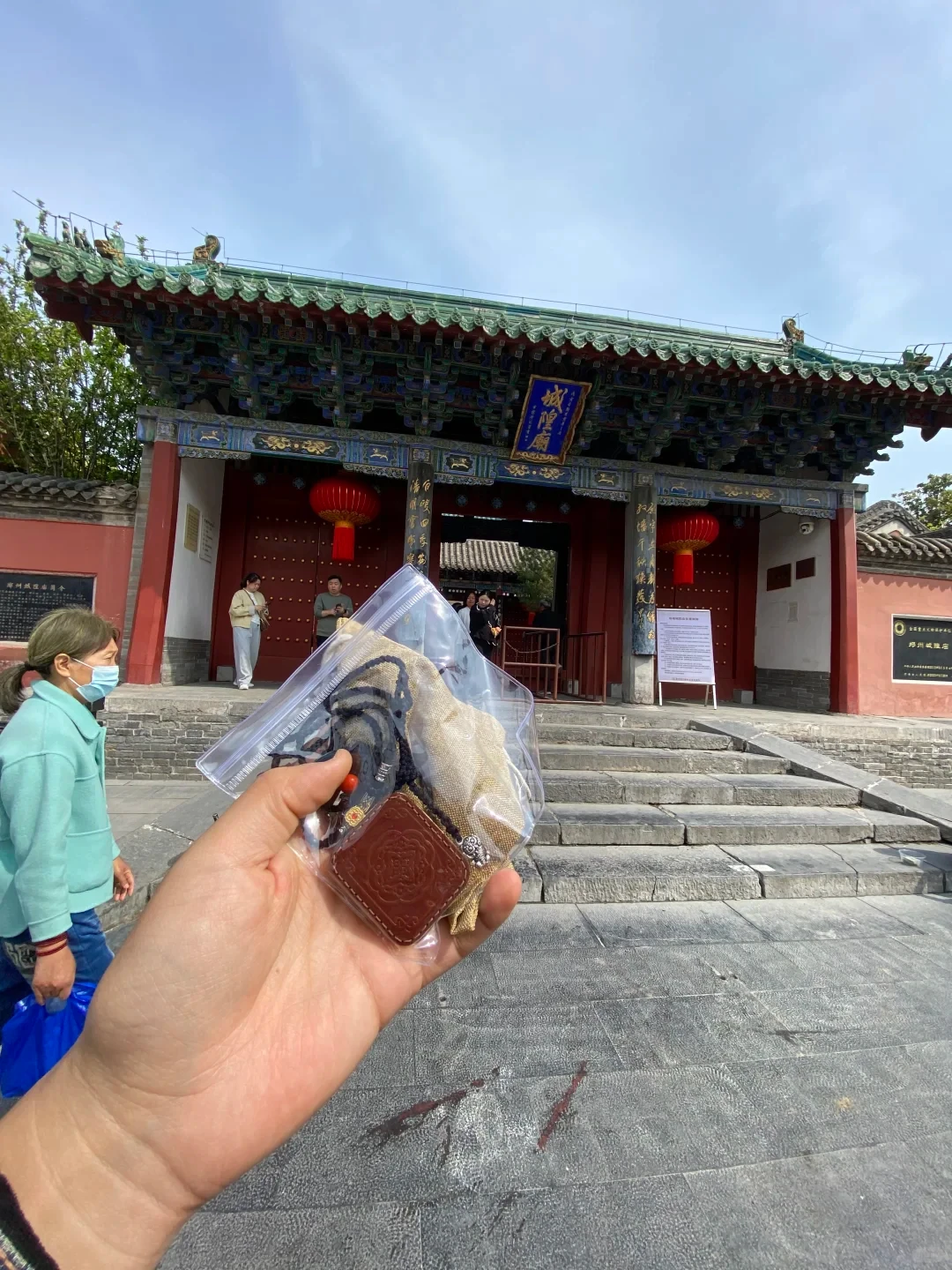 Chinese zodiac elements in lived context: visitor holding an amulet outside Zhengzhou City God Temple