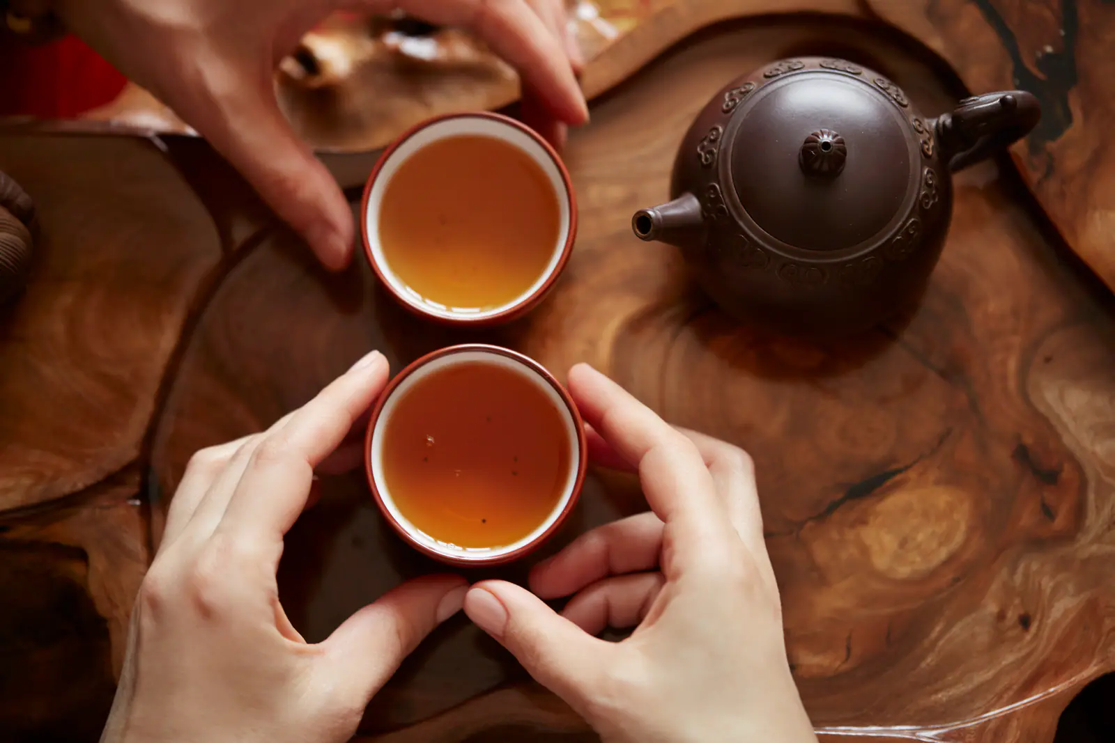 Several small cups on a tea table, emphasizing Da Hong Pao as a shared sequence rather than one oversized brew