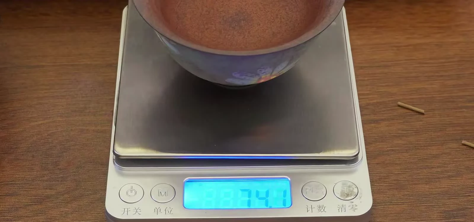 A digital scale reading 79.4 grams for water measured in a smaller gaiwan