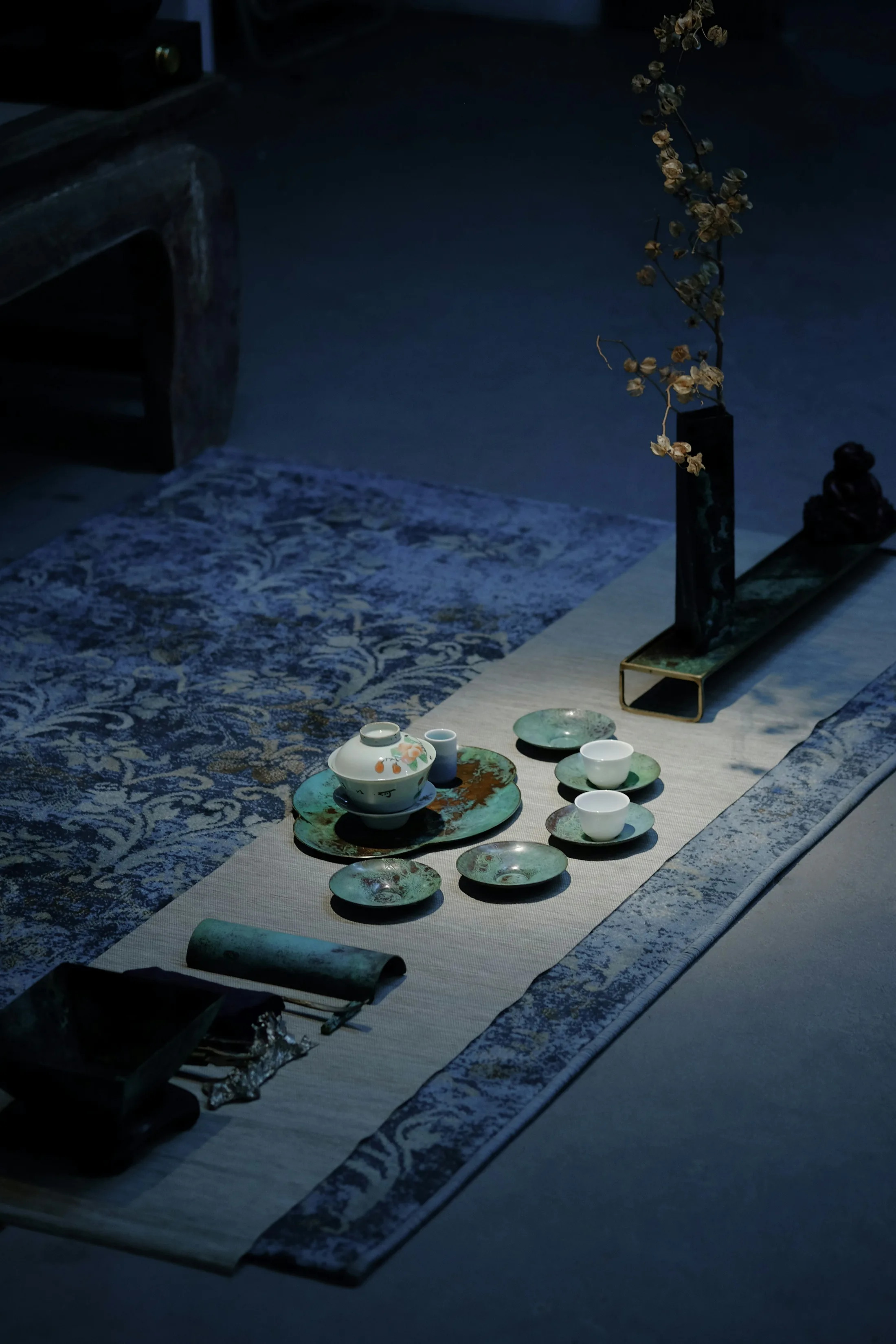 A porcelain gaiwan with cups arranged on a tea table
