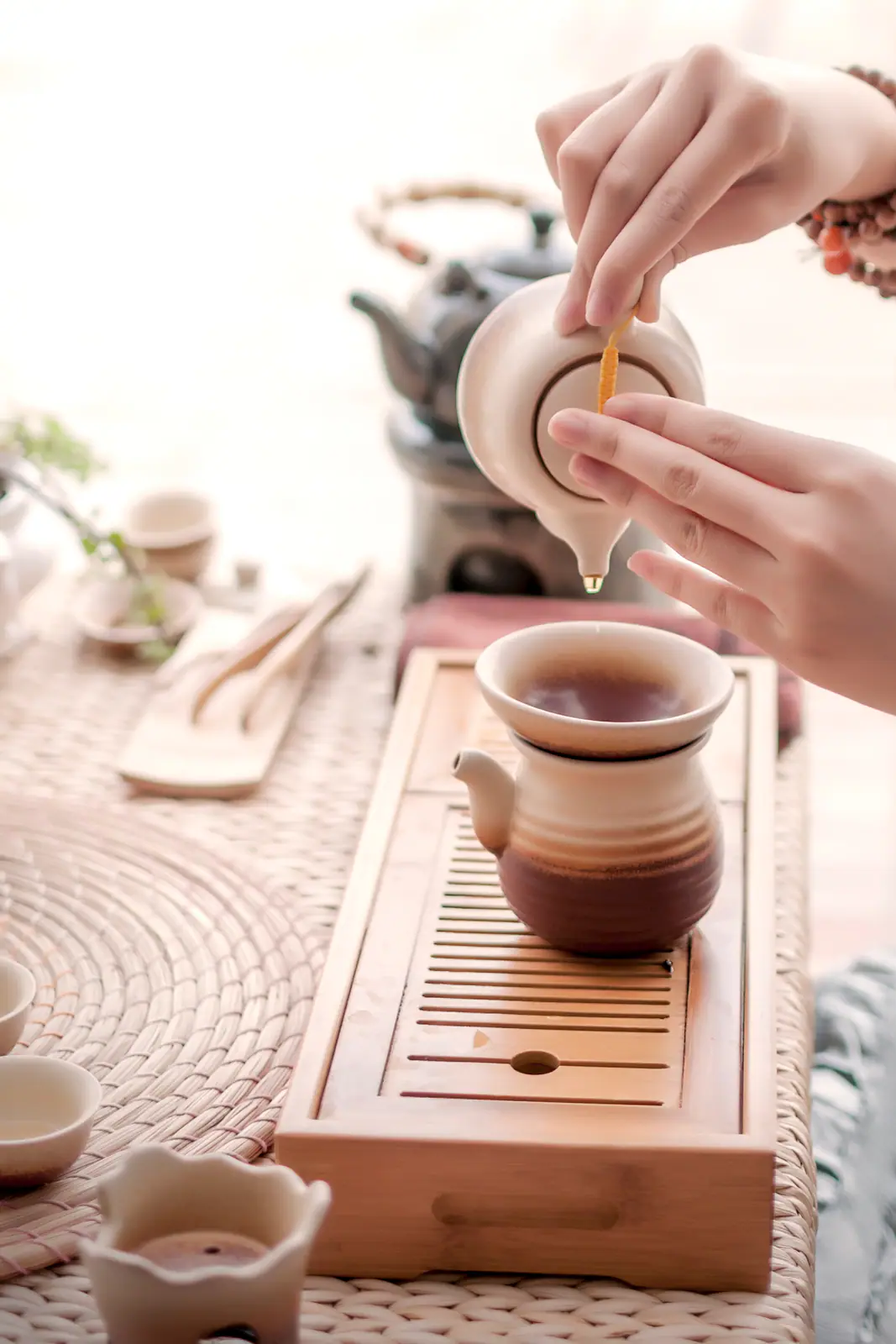 A cup held close for smelling and tasting, emphasizing how jasmine tea is judged beyond visual flowers
