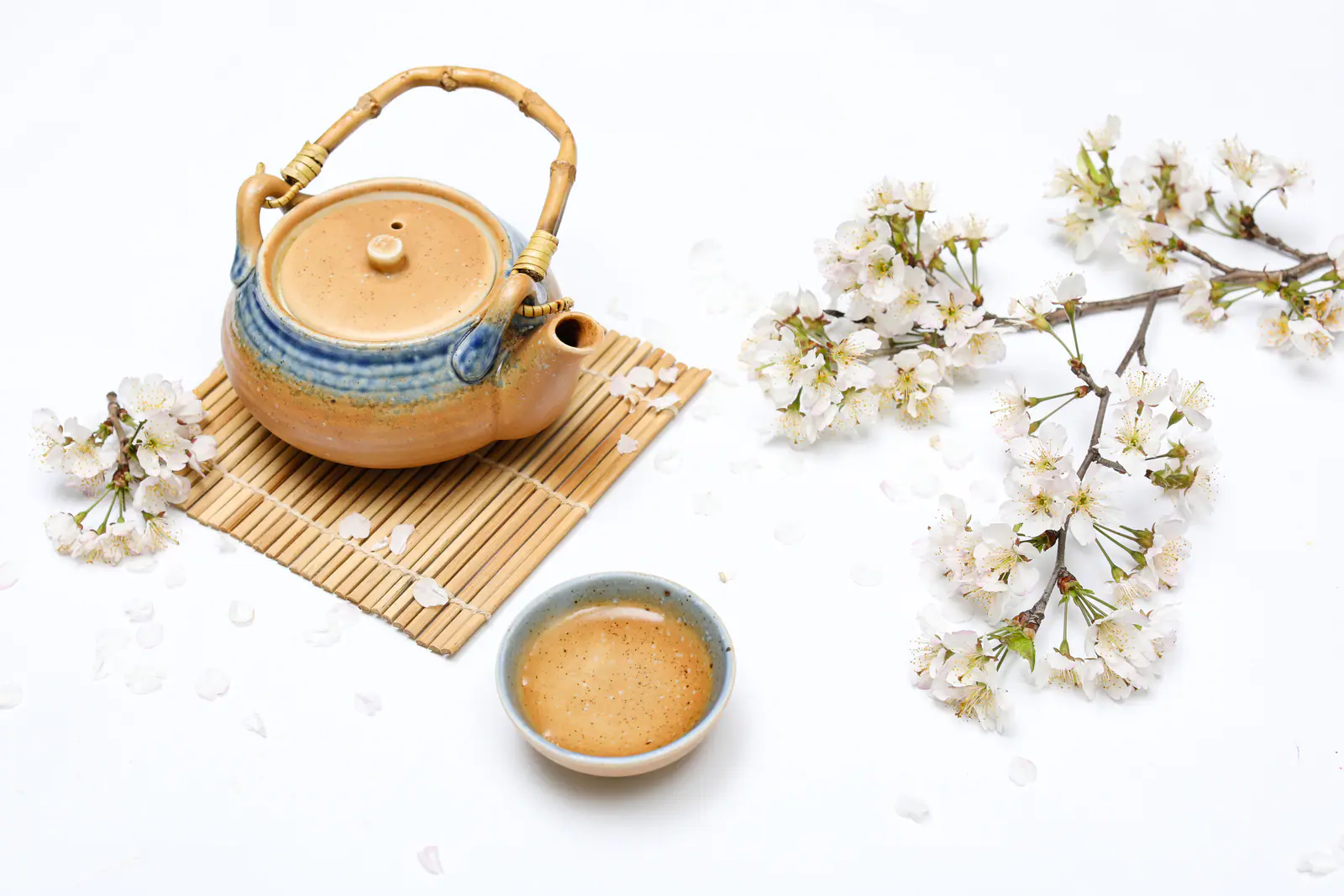 White flowers, a teapot and pale tea arranged as visual context for a jasmine tea guide