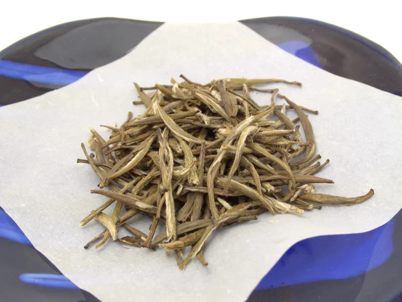 Junshan Yinzhen tea dry yellow tea buds arranged on a plate
