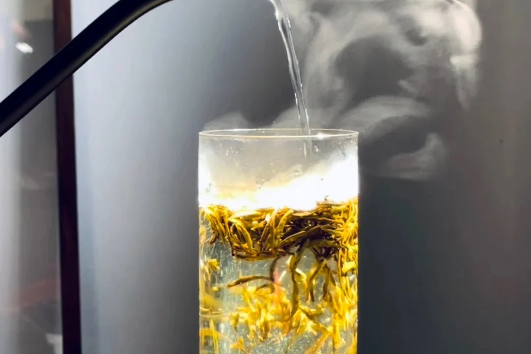 Hot water entering a glass of creator-described Junshan Yinzhen yellow tea