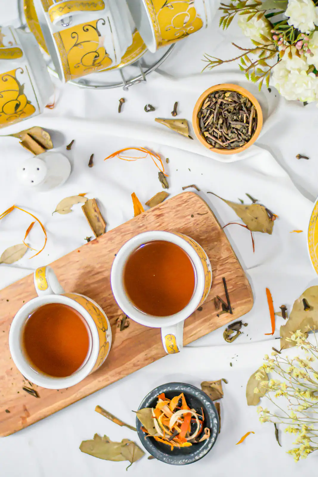 Two cups of amber tea with loose leaves in a general black-tea tasting context