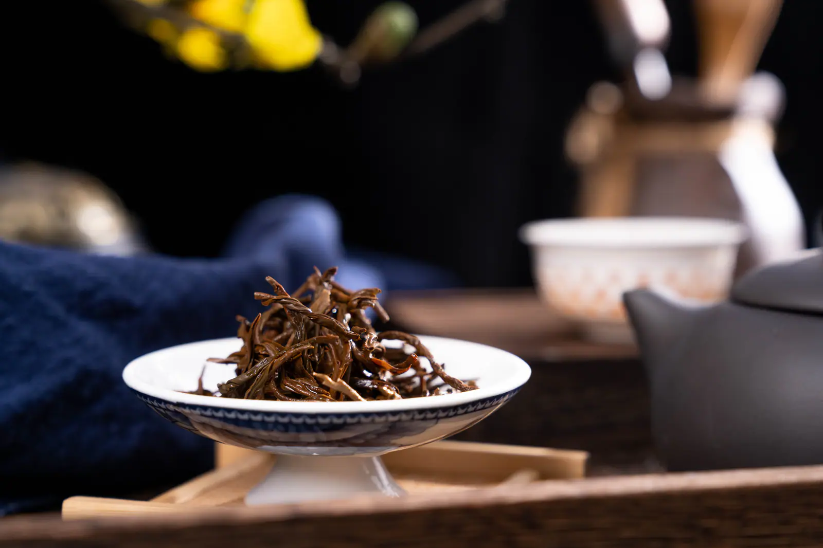 Dark leaf beside an amber cup, used to compare leaf and liquor during a Lapsang Souchong tasting