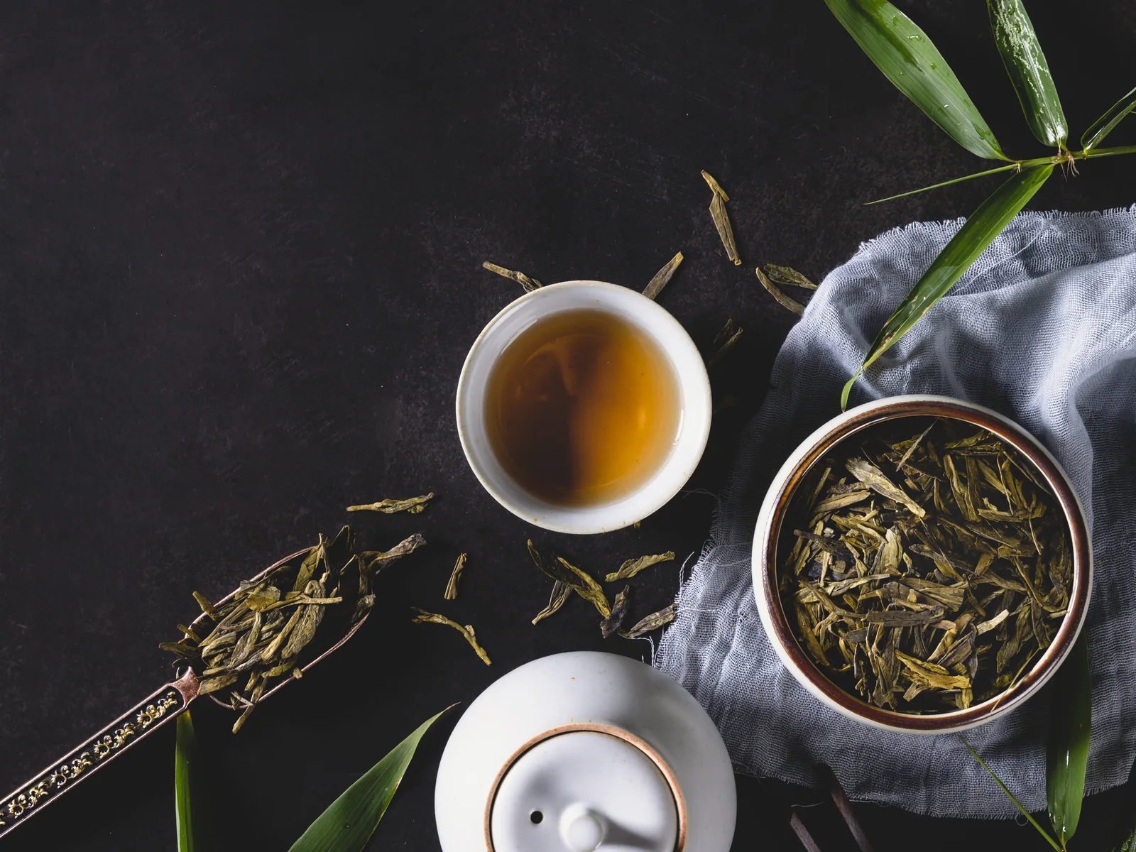 Chinese green tea dry leaves and brewed liquor arranged for a freshness and brewing guide