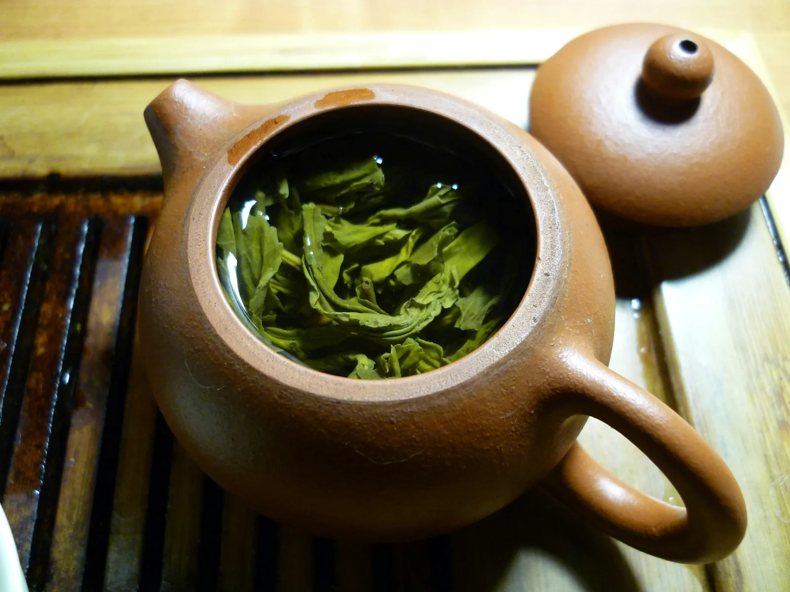 Expanded real leaves occupying most of a small brewing vessel after infusion