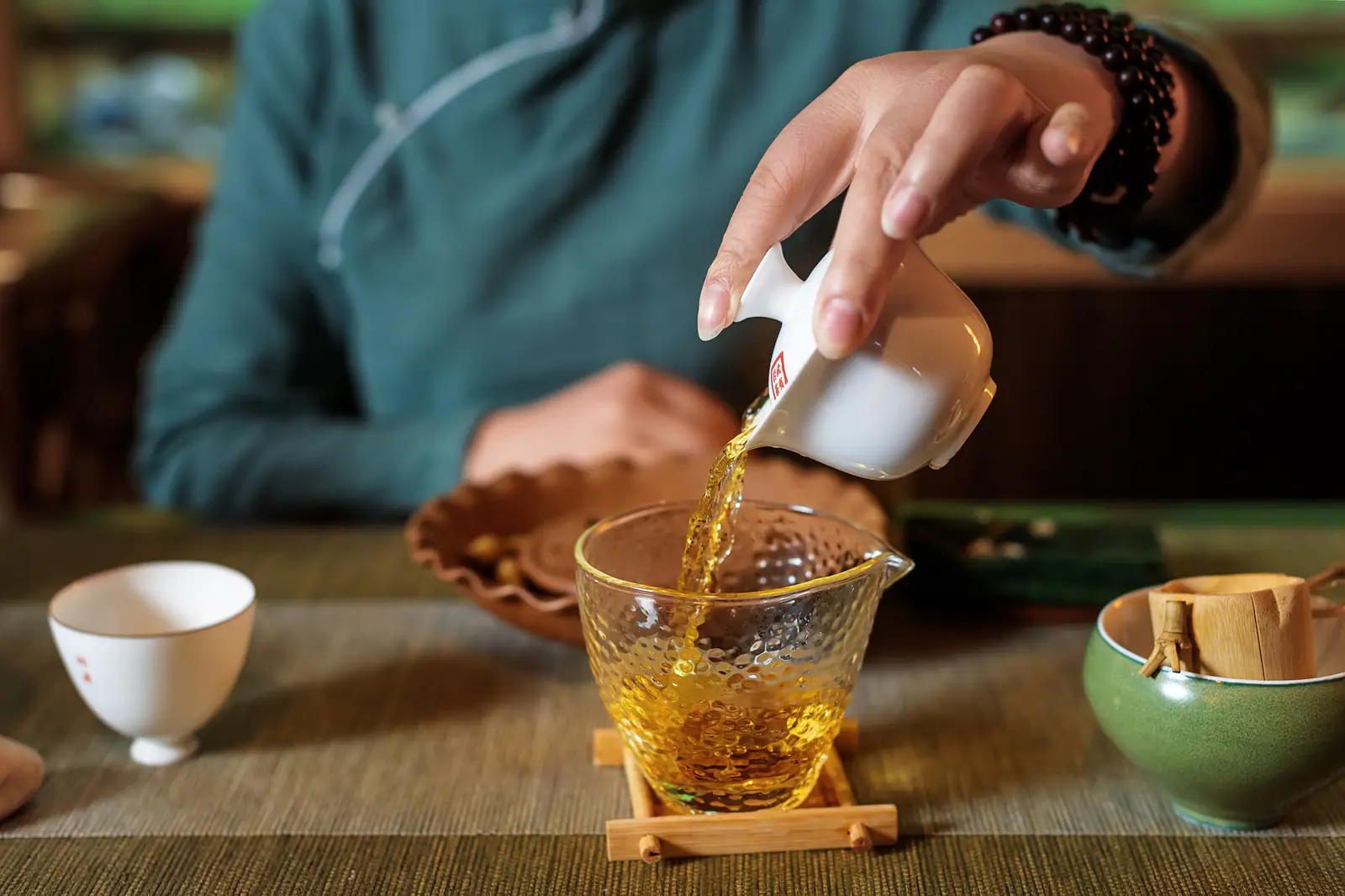 Tea poured by hand into shared cups, showing complete decanting and even service
