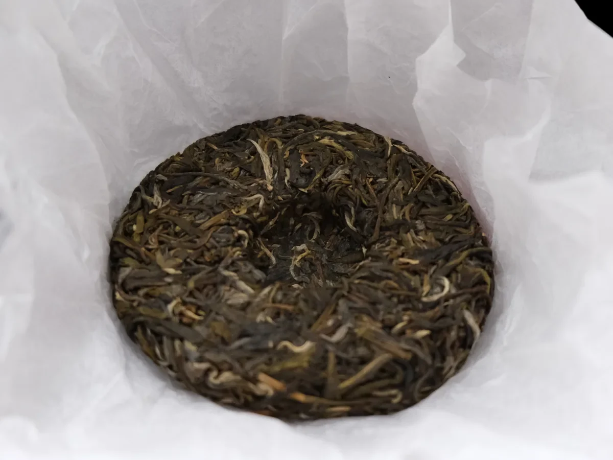 A compressed Pu-erh tea cake showing the layered edge from which a flake can be opened