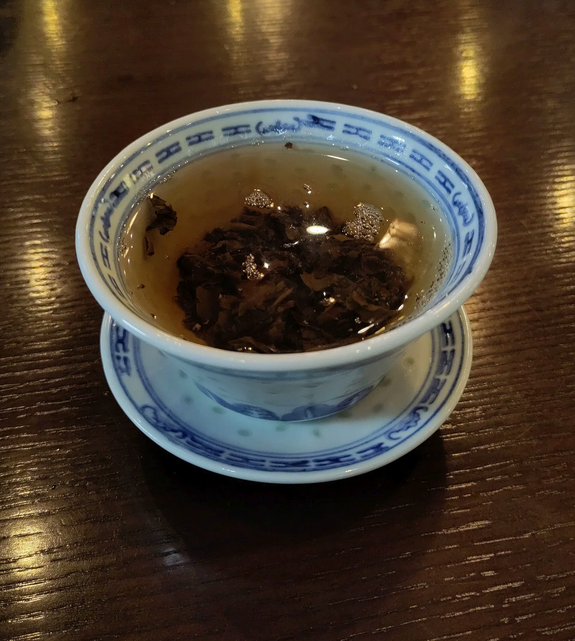Shou Mei leaves brewing in a blue and white gaiwan
