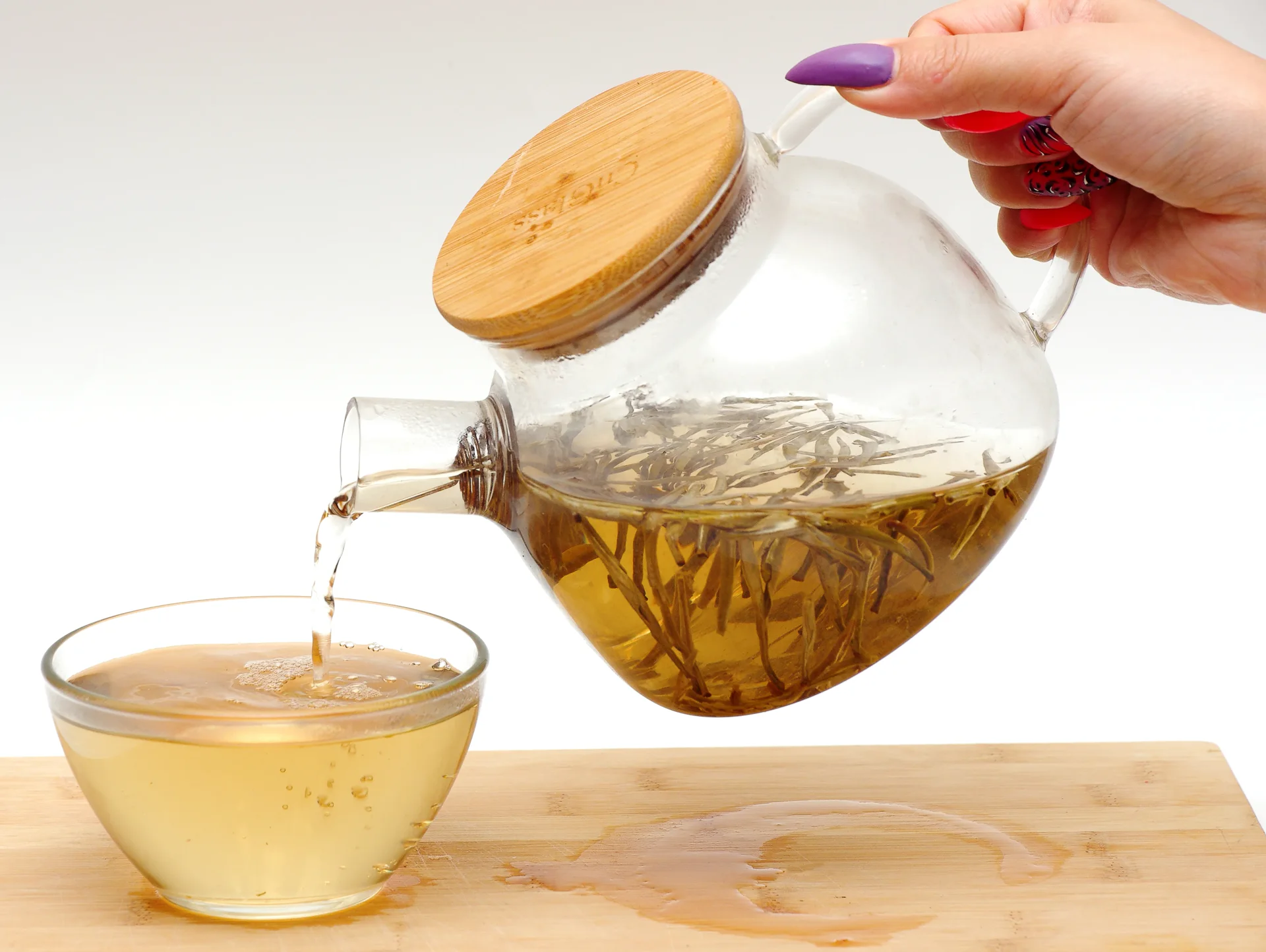 Baihao Yinzhen Silver Needle tea buds opening in a clear glass teapot