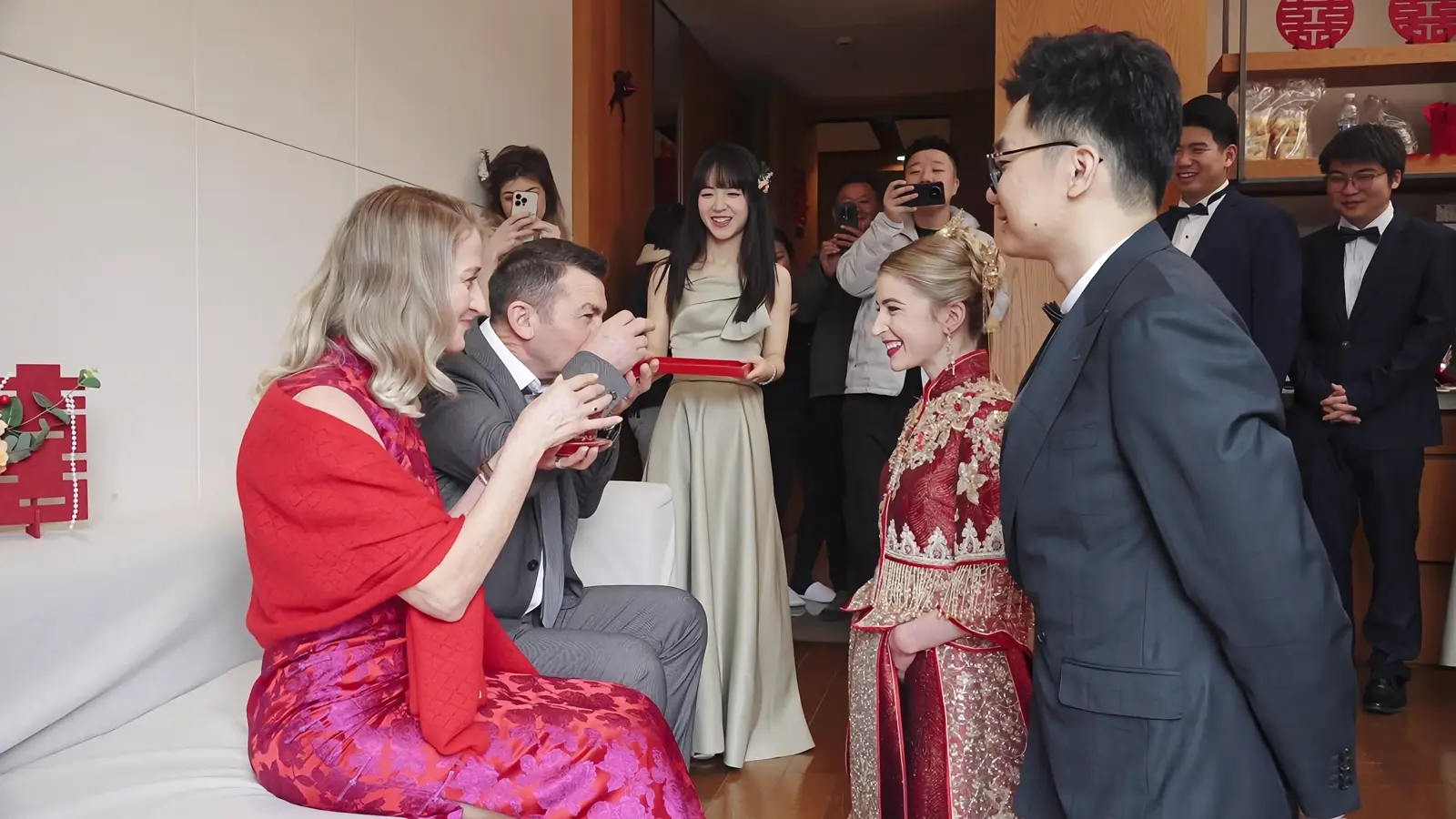 Both parents drinking after receiving tea from the wedding couple