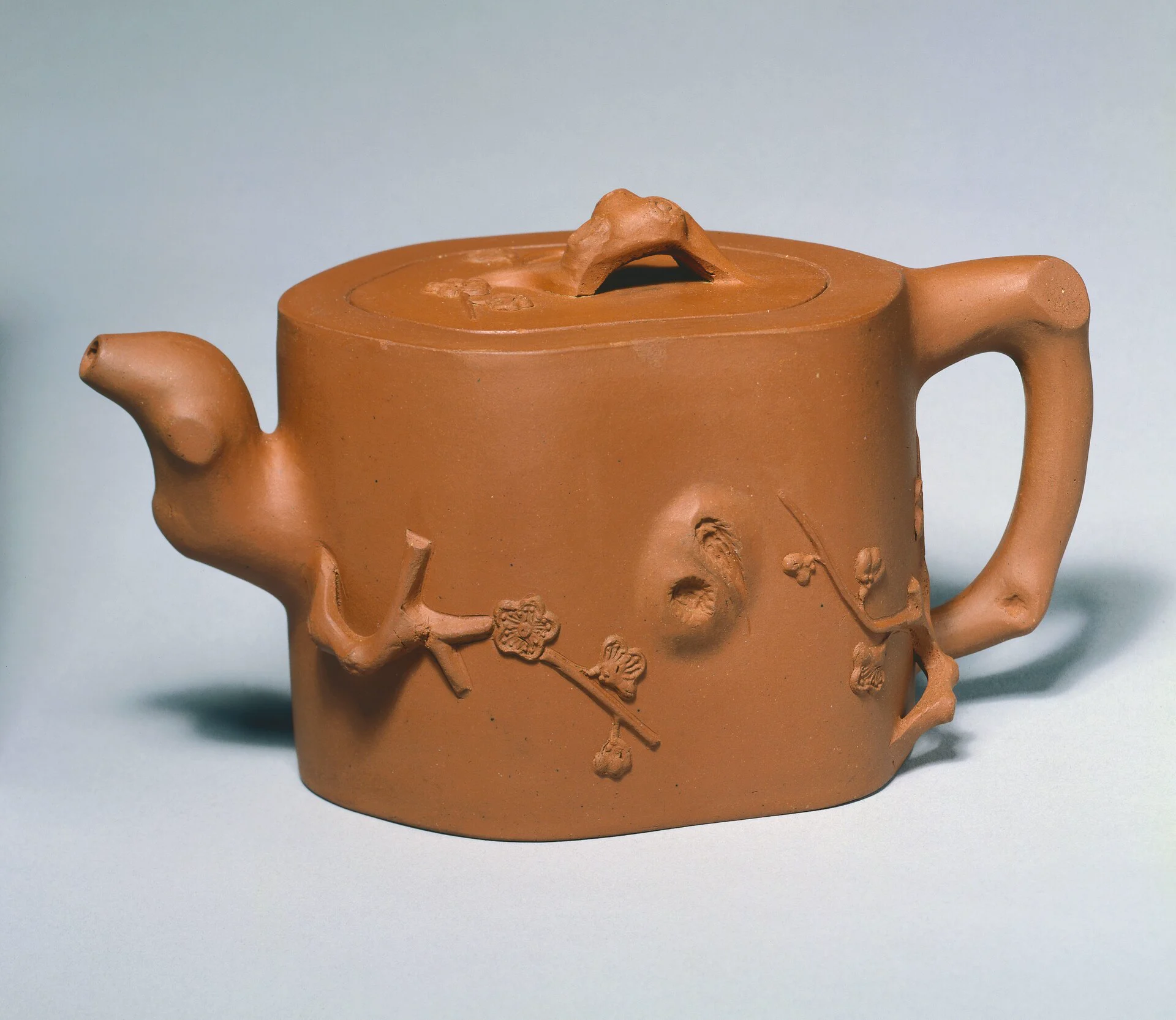 Documented Qing dynasty Yixing stoneware teapot with a warm brown body and applied flowering branch decoration