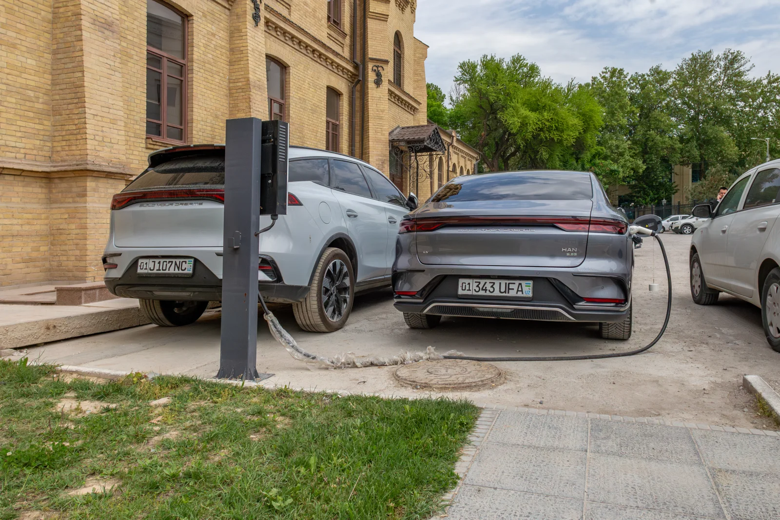 BYD Han EV connected to a local charger in Tashkent in 2025, showing a BYD car abroad but not US charging compatibility
