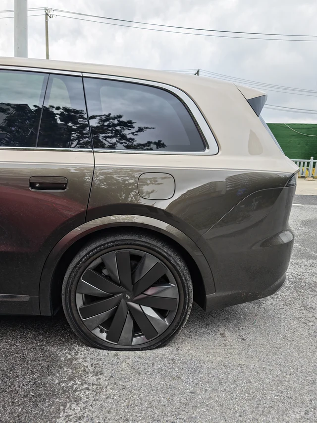 Close view of the rear side and wheel of a two-tone Li Auto L9