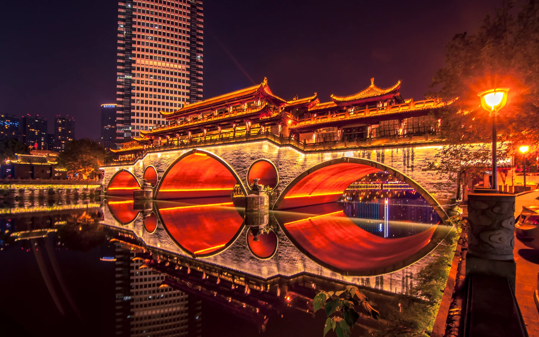 Jiuyan Bridge showing the riverside scale travelers meet after dark