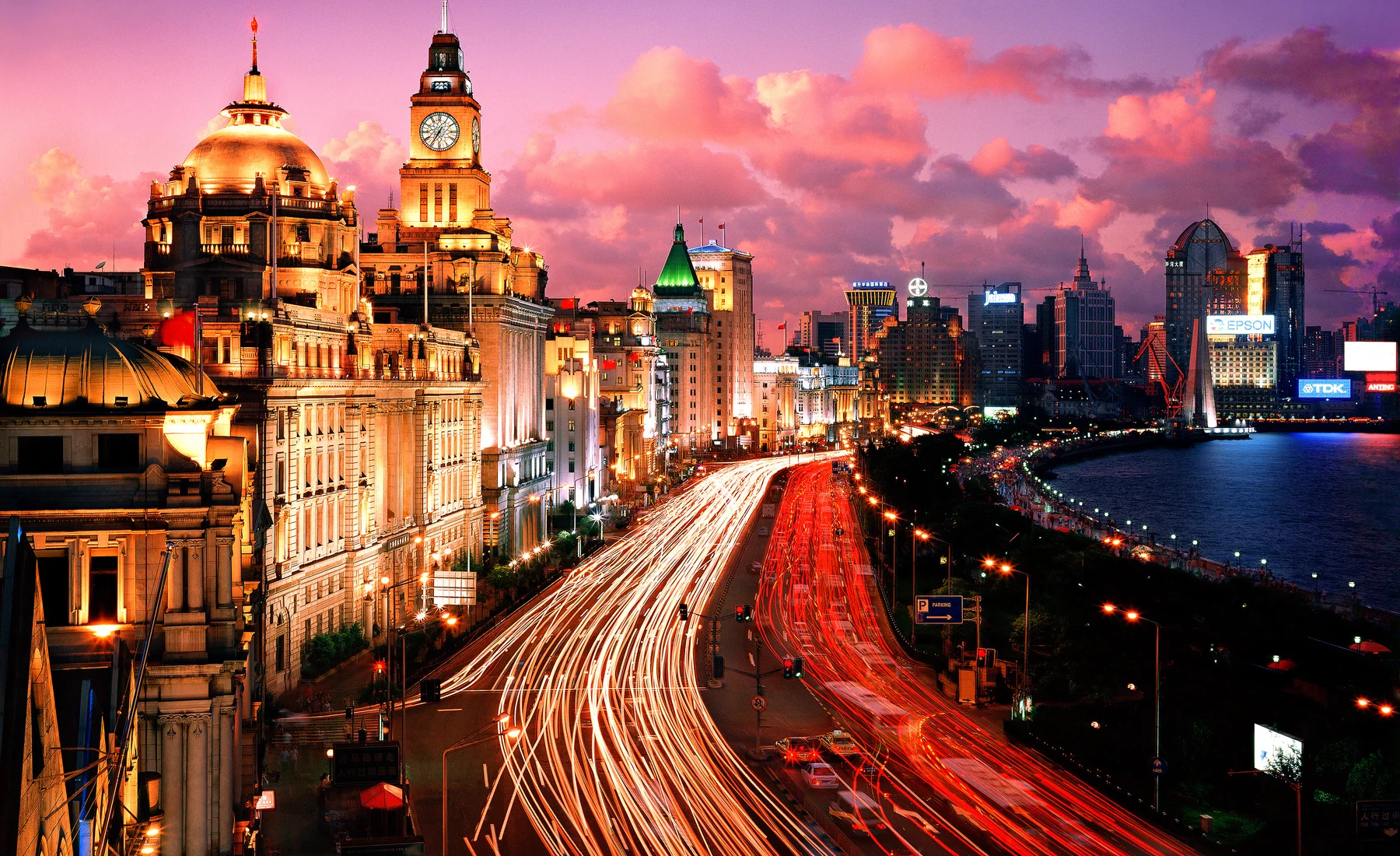 The Bund's historic facade line and traffic corridor at dusk, with the riverfront read from the west bank rather than reduced to Pudong towers