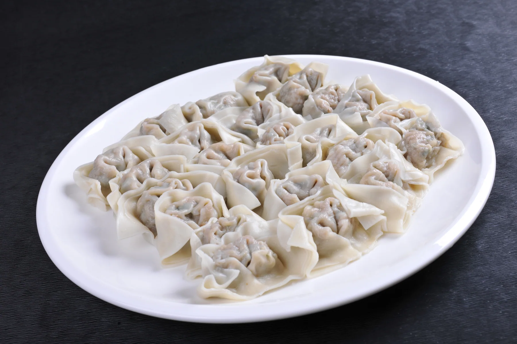 Large Shanghai-style wontons showing the loose folded wrapper and generous filling