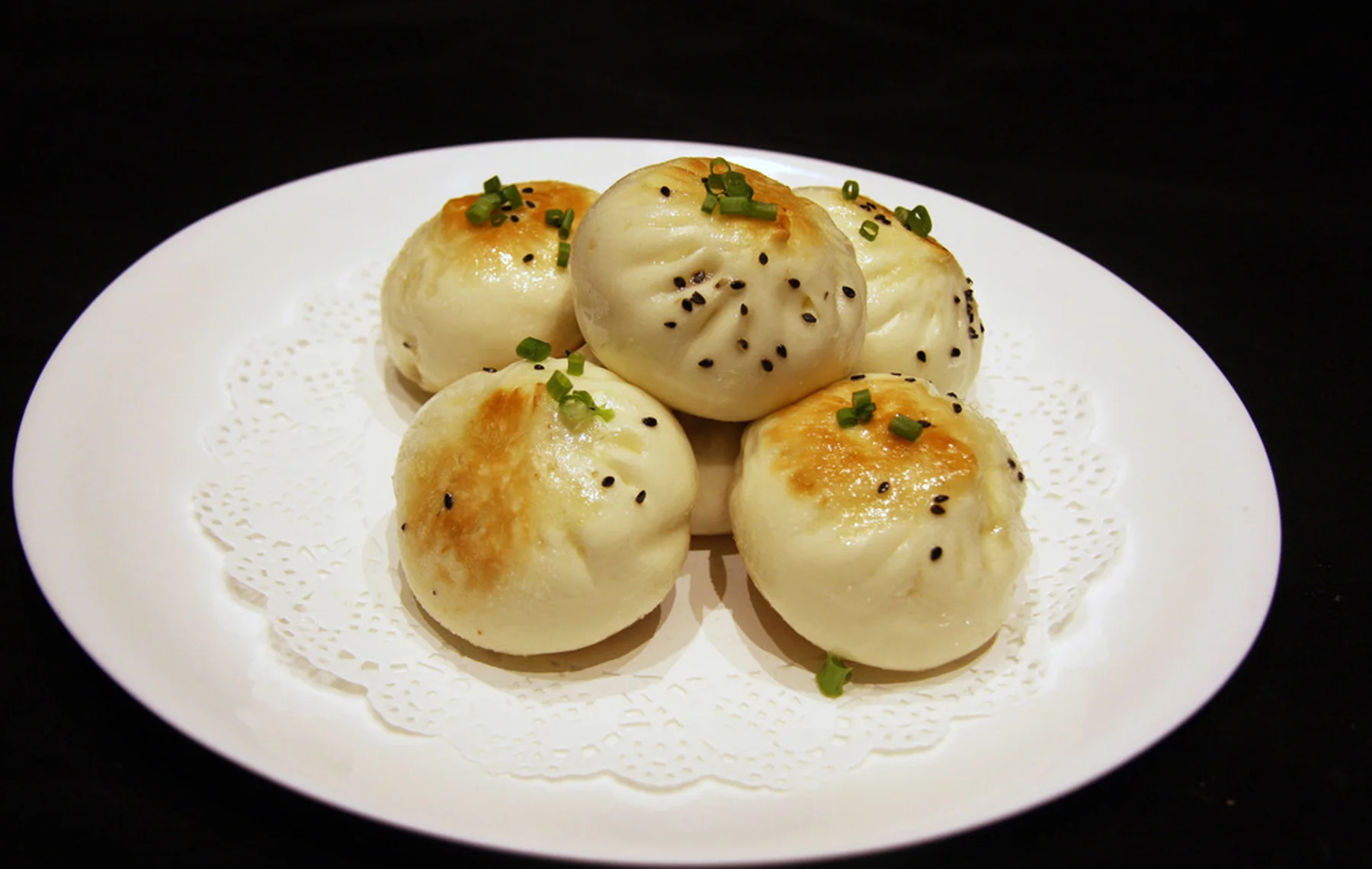 Shanghai shengjian with browned pan-seared bottoms, sesame and spring onion
