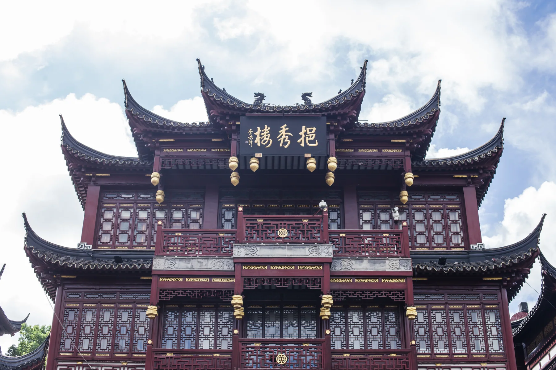 The layered roofline and carved facade of Yixiu Tower in the Yuyuan visitor district