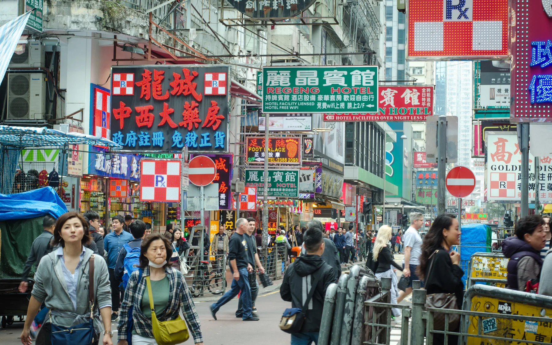 Crowded Hong Kong street with Traditional Chinese signs, compact shops and pedestrians moving through the commercial district