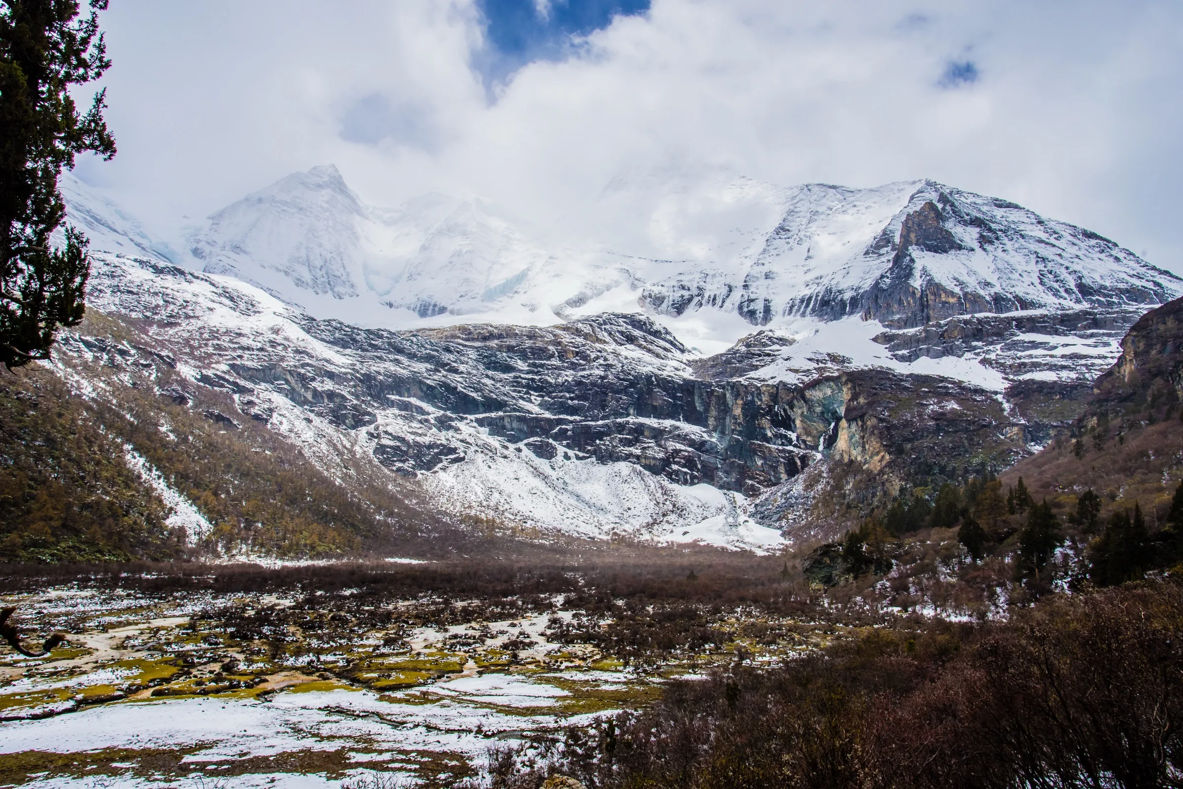 Xiannairi rising above a broad alpine valley in Daocheng Yading