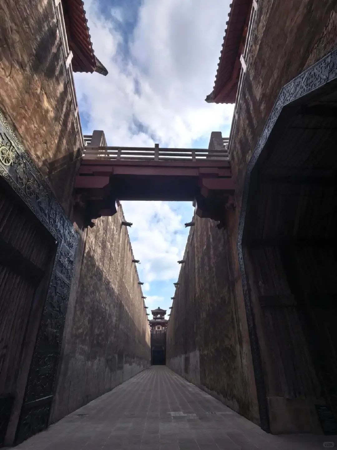 A narrow service passage between massive set walls at Hengdian's Qin Palace