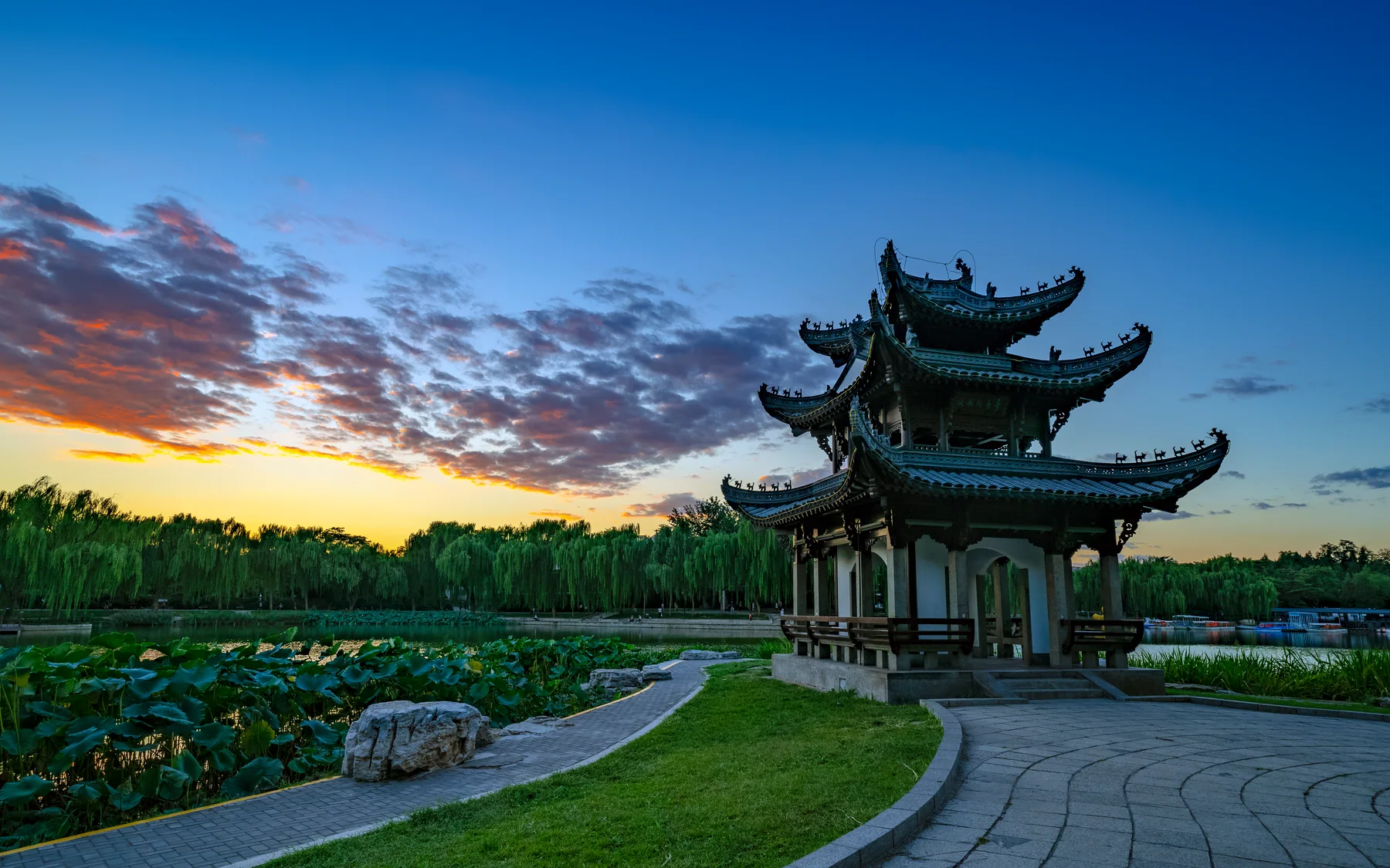 A waterside pavilion at dusk showing how public landscape changes when the route reaches evening