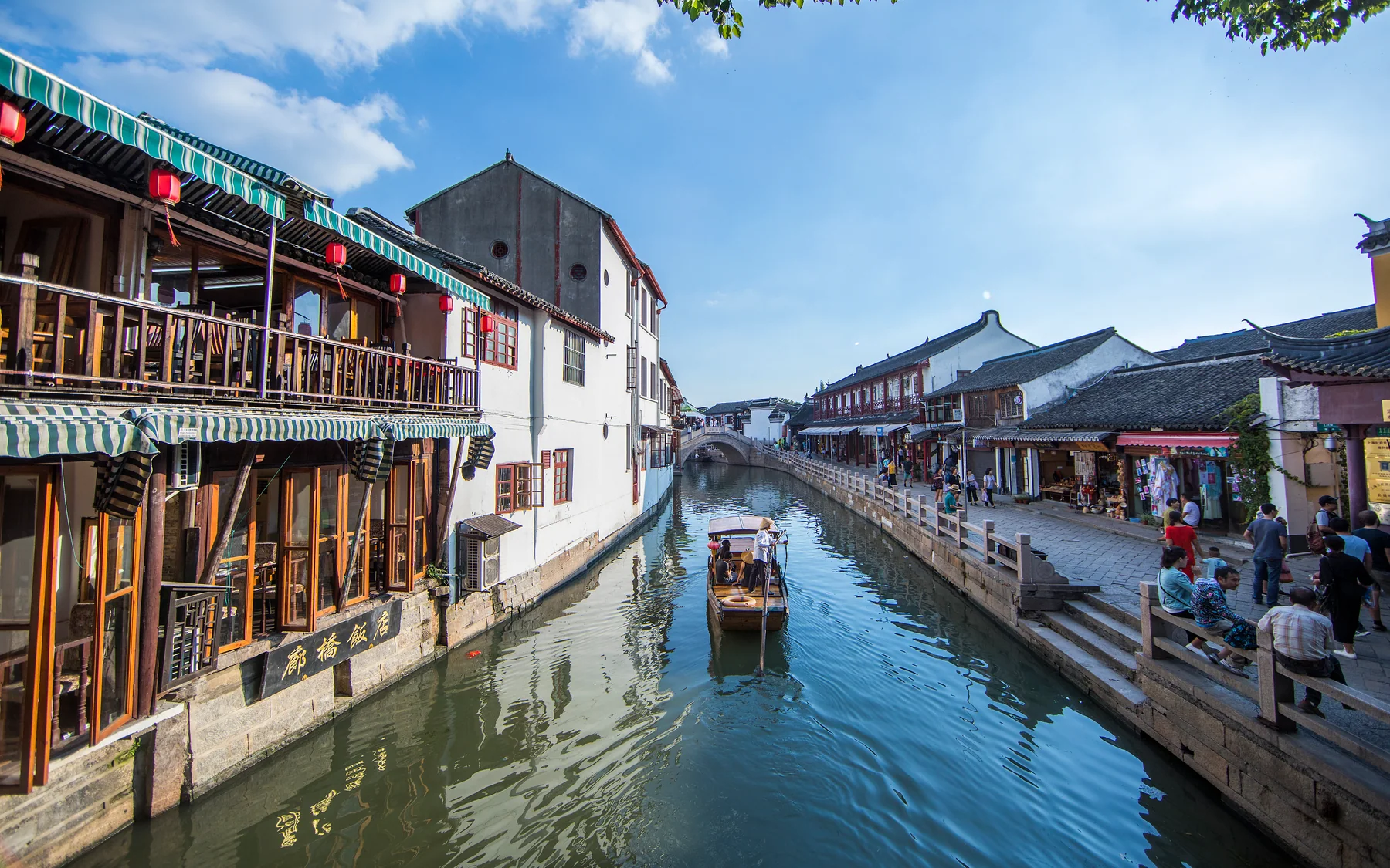 Canal boat and active commercial banks showing Jiangnan water as movement rather than surface decoration